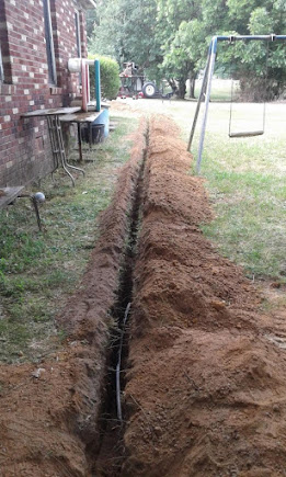 Freshly excavated sewer line trench across a Queen Creek backyard